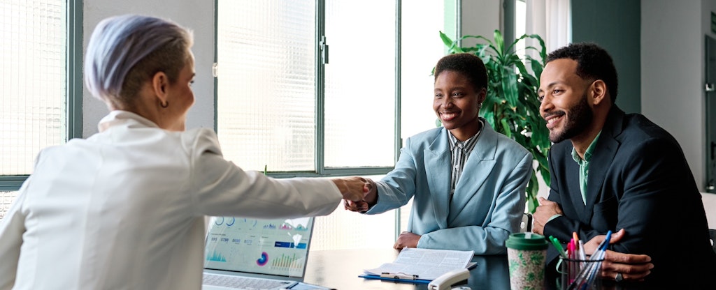 Businesswoman shaking hands to close a deal with clients in the office.