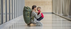 African American soldier hugging son in airport