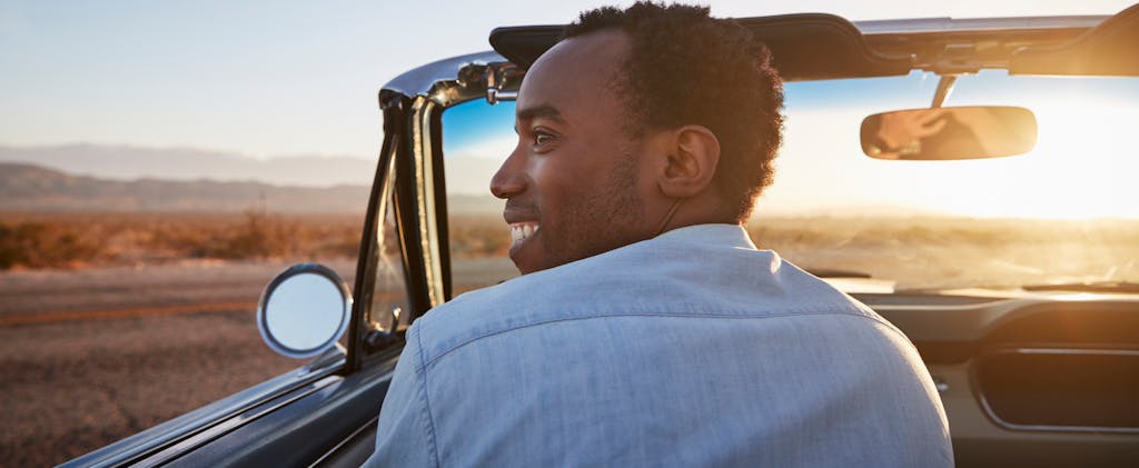 Man driving a classic convertible in a southwestern U.S. desert