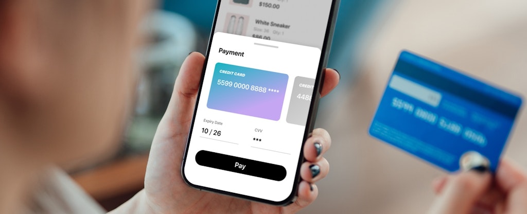 Over the shoulder view of woman doing online shopping on smartphone.