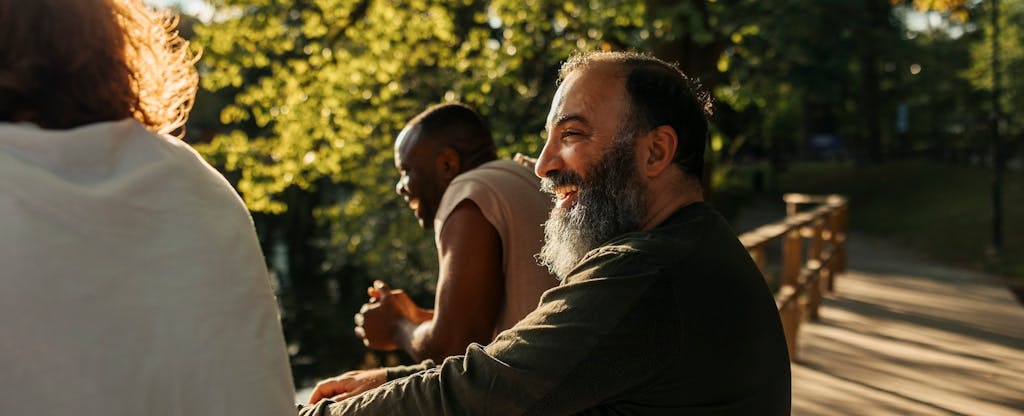 Group of men smiling outdoors in a park