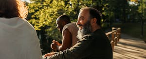 Group of men smiling outdoors in a park