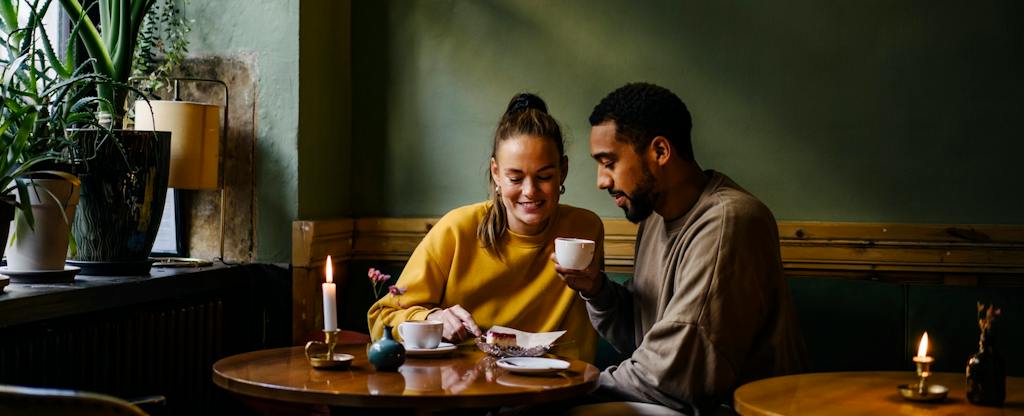 Couple having cappuccinos and cheesecake in coffee shop