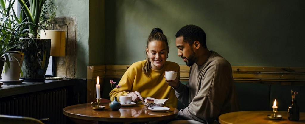 Couple having cappuccinos and cheesecake in coffee shop