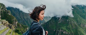 Young woman looking at view from the Machu Picchu mountains in Peru.