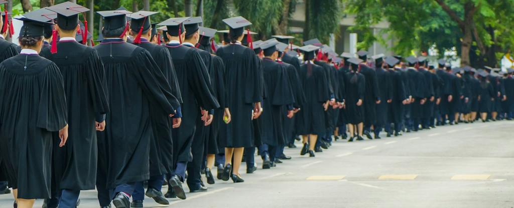 student-loan-debt-report The rear view of graduates in traditional caps and gowns, symbolizing the culmination of their academic journey.